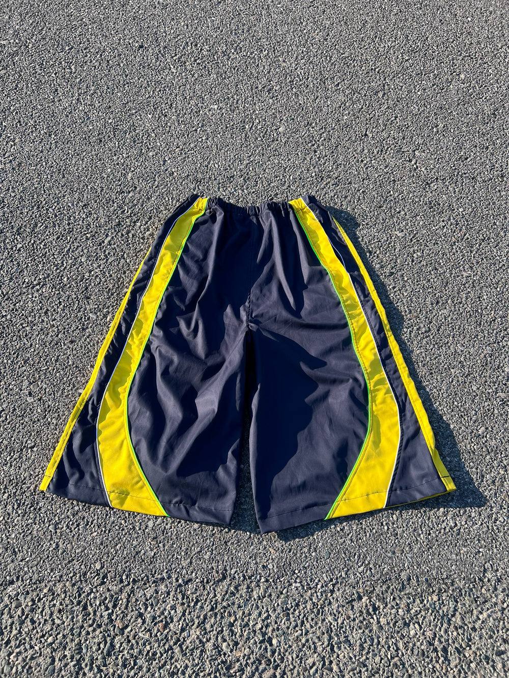 Pantaloncini sportivi EMANUELE MONACO STORE blu scuro con inserti gialli e profili bianchi, taglio ampio e tecnico.